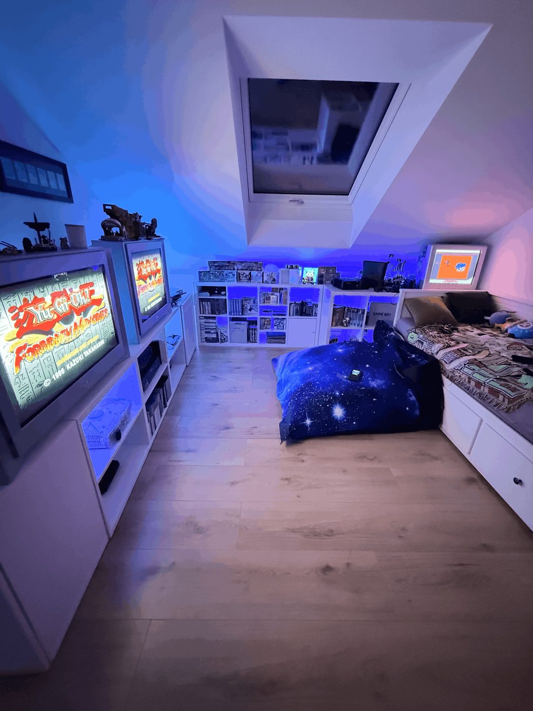 Buri’s retro gaming room: CRT TVs running Yu-Gi-Oh Forbidden Memories, shelves of games and a Game Boy bed nook
